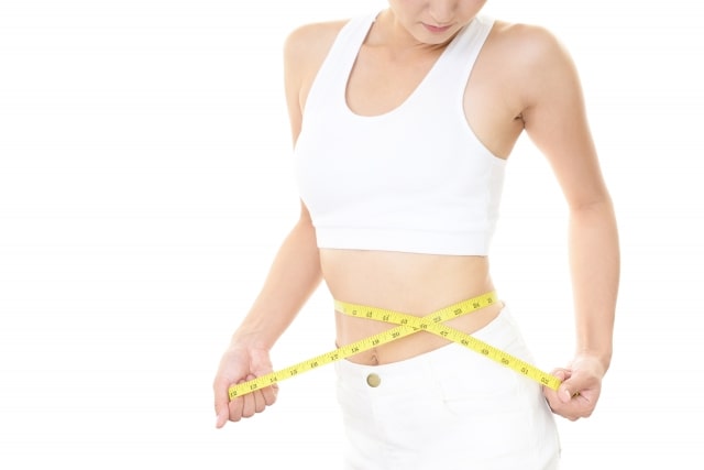 メジャーでお腹を測る女性