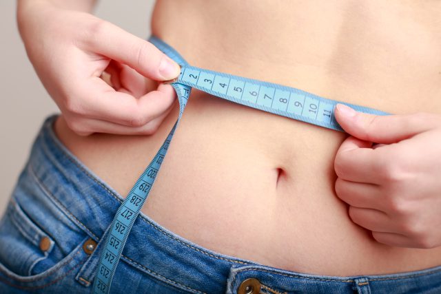 ウエストを測る女性