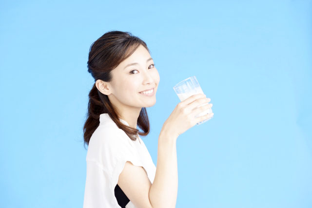 アーモンドミルクを飲む女性