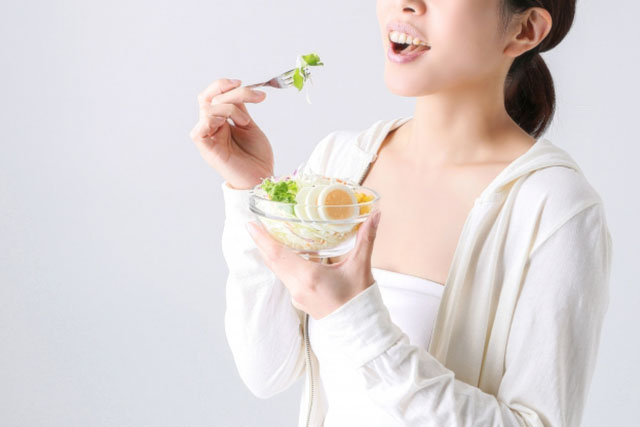 サラダを食べる女性