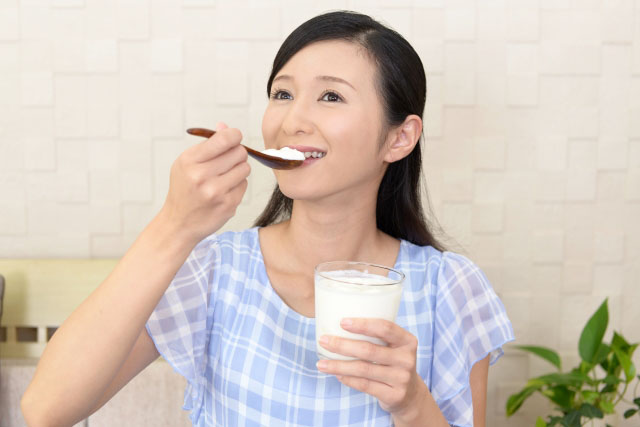 ヨーグルトを食べる女性