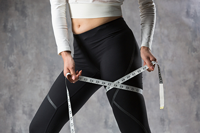 メジャーで足を測る女性