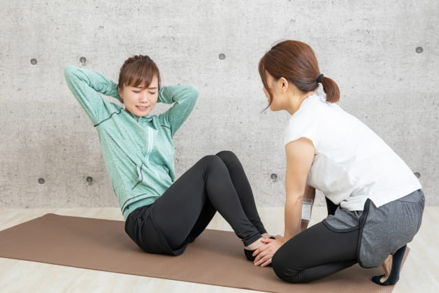 苦しそうに腹筋をする女性