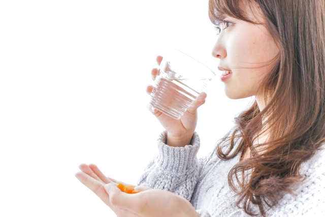 サプリメントを飲む女性
